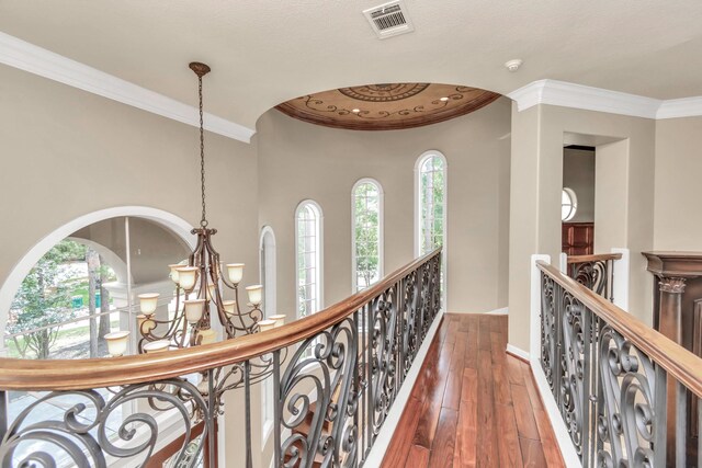 hall featuring a notable chandelier, dark hardwood / wood-style flooring, and crown molding