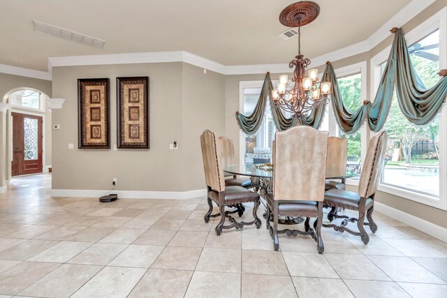 tiled dining space featuring crown molding and a chandelier