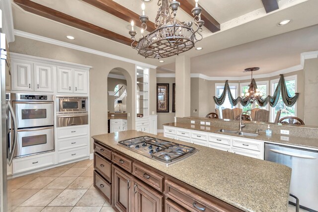 kitchen featuring white cabinetry, a breakfast bar area, light tile patterned floors, stainless steel appliances, and sink