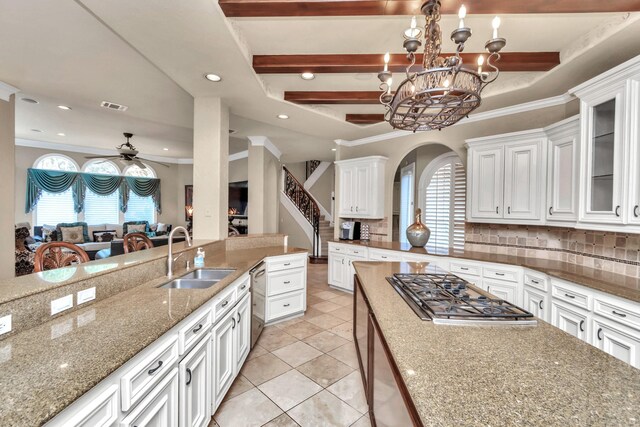 kitchen with white cabinetry, backsplash, ceiling fan with notable chandelier, and sink