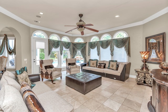 tiled living room with ornamental molding and ceiling fan