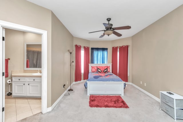 carpeted bedroom with ensuite bathroom, sink, and ceiling fan