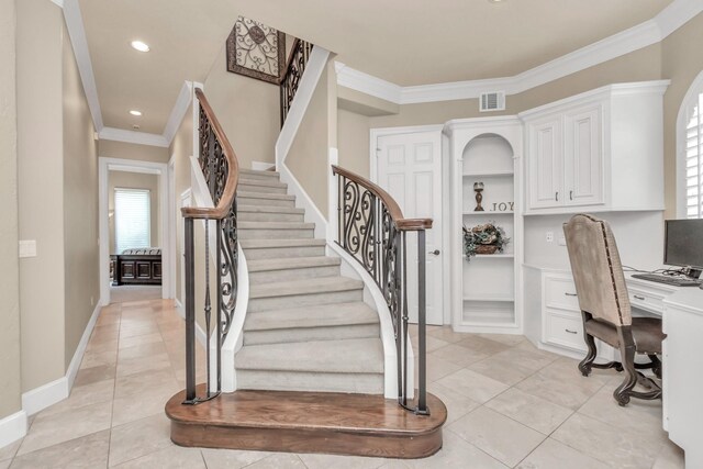 stairway featuring built in shelves, built in desk, ornamental molding, and light tile patterned floors