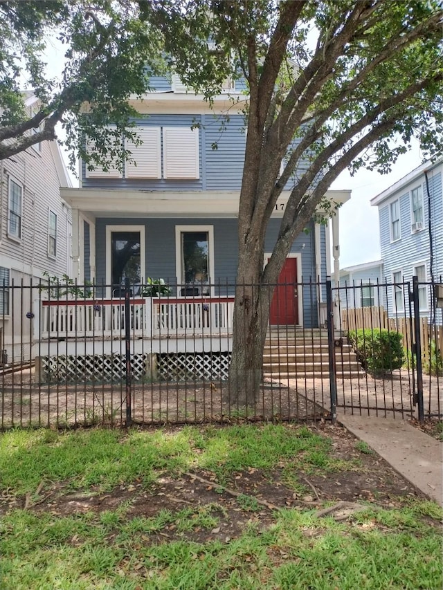 view of front of property featuring fence private yard and covered porch