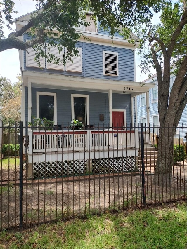 view of front facade featuring fence private yard and covered porch