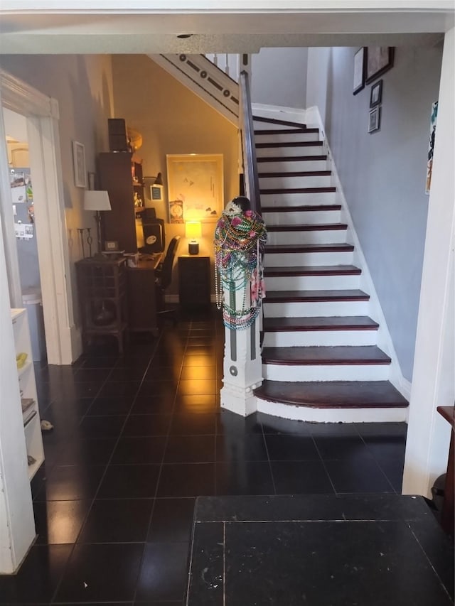 stairs featuring tile patterned floors and baseboards