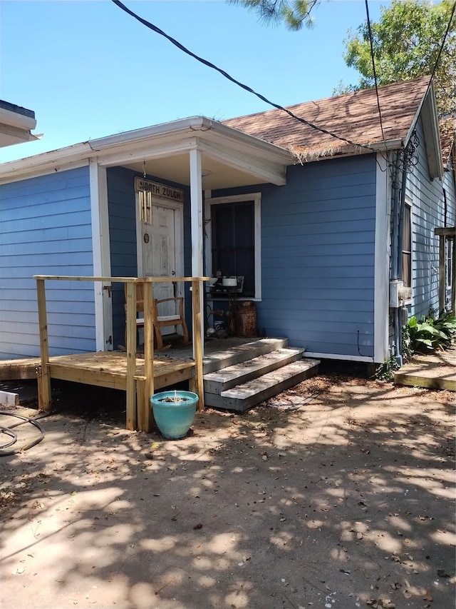 exterior space with a shingled roof and covered porch