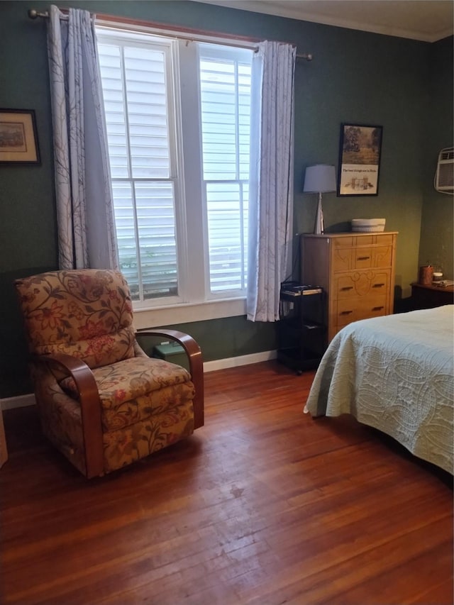 bedroom featuring crown molding, baseboards, multiple windows, and wood finished floors