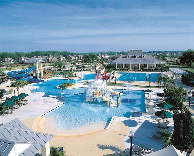 view of swimming pool with pool water feature and a water slide