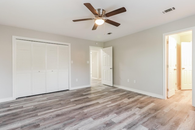 unfurnished bedroom featuring ceiling fan, light hardwood / wood-style floors, and a closet