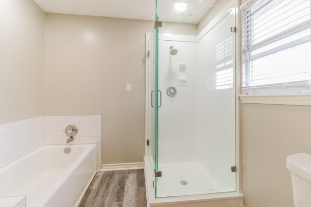 bathroom featuring separate shower and tub, wood-type flooring, and toilet