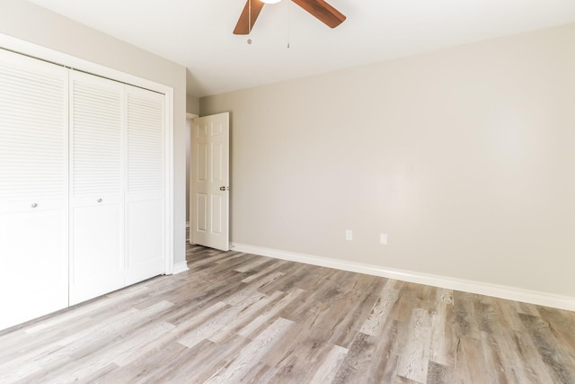 unfurnished bedroom with ceiling fan, a closet, and light hardwood / wood-style flooring