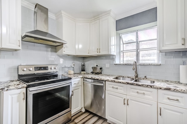 kitchen with appliances with stainless steel finishes, white cabinetry, sink, wall chimney range hood, and tasteful backsplash