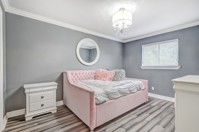 bedroom with an inviting chandelier, light hardwood / wood-style floors, and ornamental molding