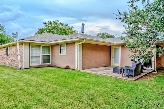 rear view of house featuring a lawn and a patio