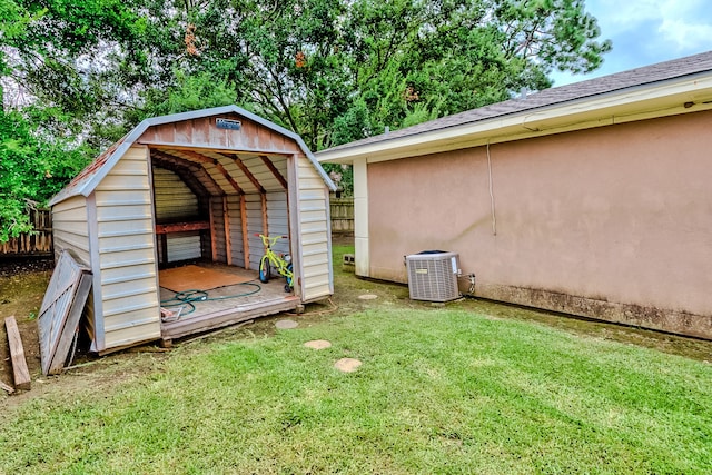 view of outbuilding featuring a yard and central AC