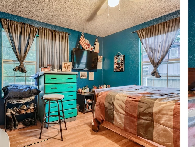 bedroom featuring a textured ceiling, ceiling fan, and wood-type flooring