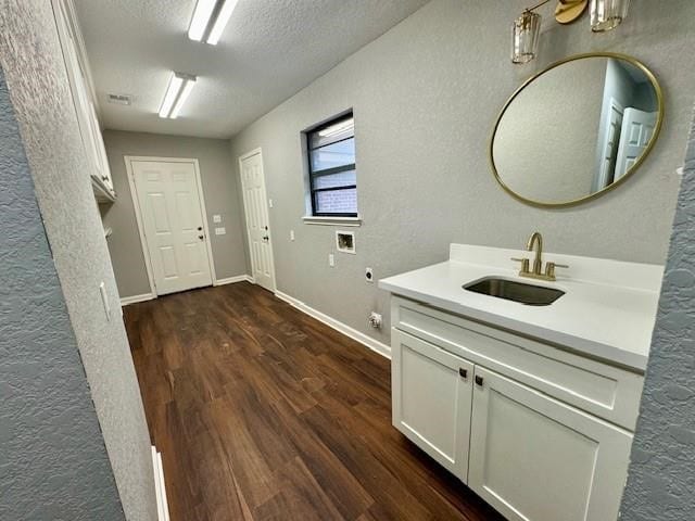 bathroom with wood-type flooring, sink, and a textured ceiling