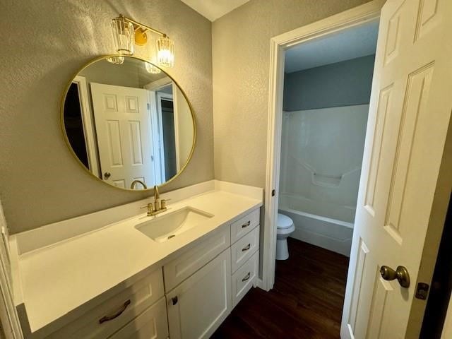 full bathroom with hardwood / wood-style flooring, toilet, vanity, and shower / bathtub combination