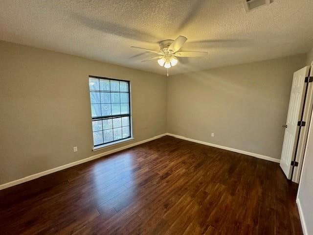 empty room with dark wood-type flooring, a textured ceiling, and ceiling fan