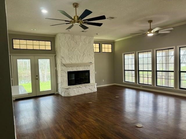 unfurnished living room with plenty of natural light, dark wood-type flooring, and ornamental molding