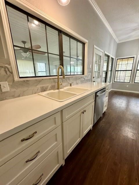 kitchen with white cabinetry, dishwasher, dark wood-type flooring, sink, and ornamental molding