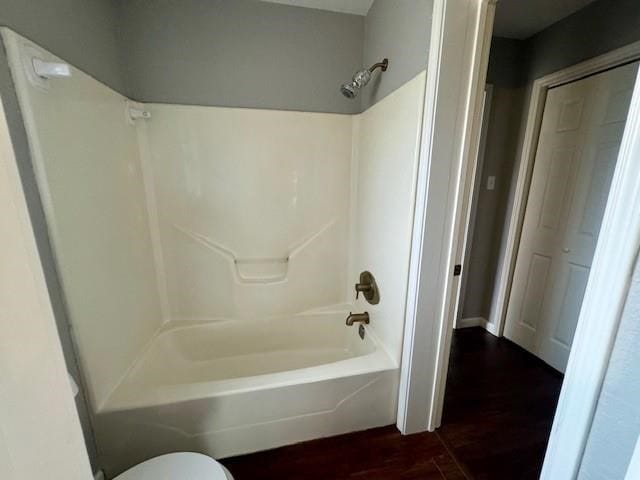 bathroom featuring tub / shower combination, toilet, and hardwood / wood-style floors