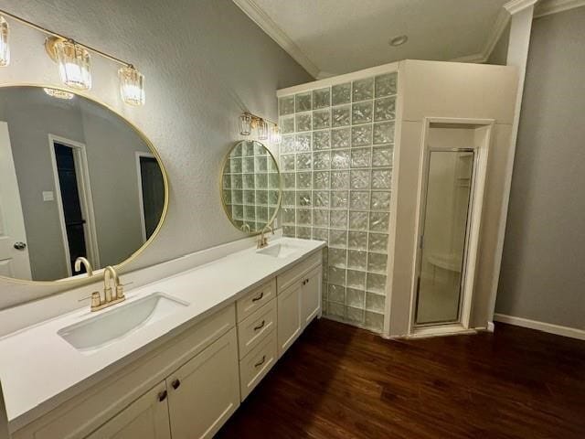 bathroom featuring ornamental molding, wood-type flooring, an enclosed shower, and double vanity