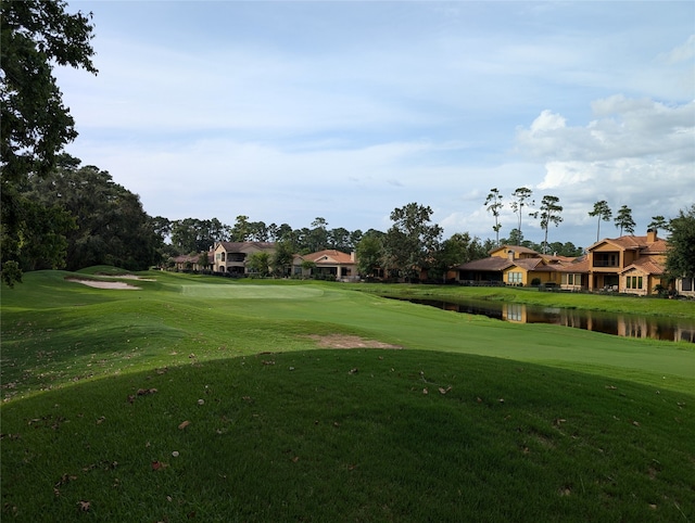 view of property's community with a lawn and a water view