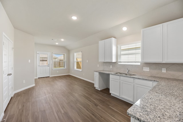 kitchen featuring white cabinetry, dark hardwood / wood-style flooring, lofted ceiling, and backsplash