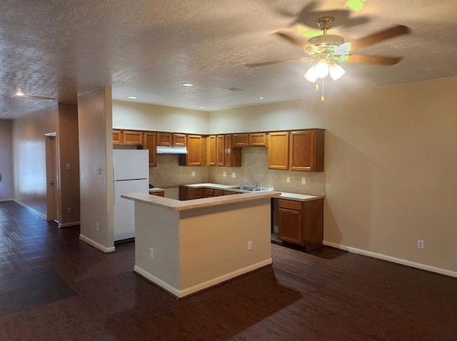 kitchen featuring white fridge, a textured ceiling, a kitchen island, ceiling fan, and decorative backsplash