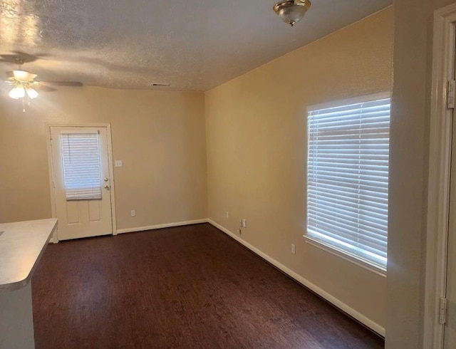 unfurnished room with dark hardwood / wood-style floors, ceiling fan, and a textured ceiling