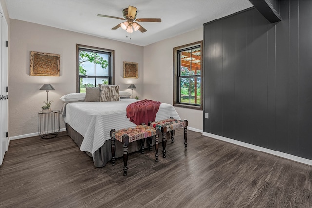 bedroom with dark wood-type flooring, ceiling fan, and multiple windows