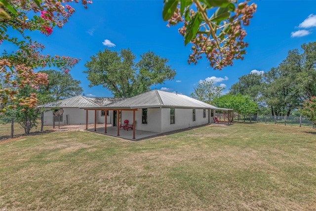 rear view of property featuring a yard and a patio area