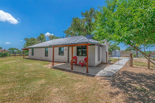 rear view of house with a storage unit, a patio, and a yard