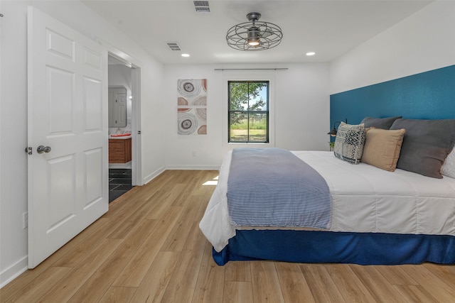 bedroom featuring light hardwood / wood-style flooring and ensuite bath