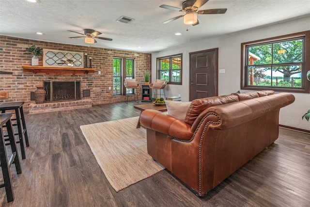 living room with dark hardwood / wood-style floors, brick wall, and a textured ceiling