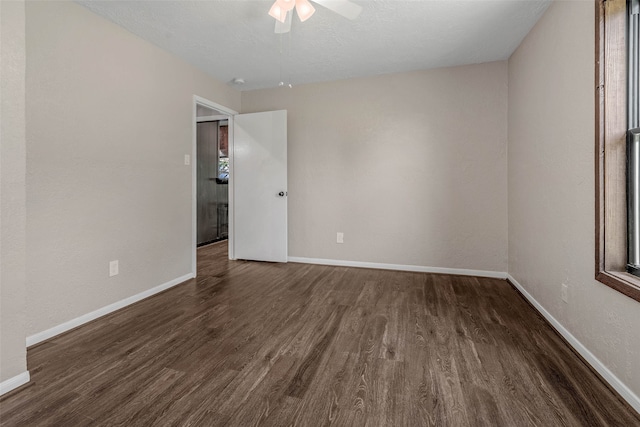 spare room featuring ceiling fan and dark wood-type flooring