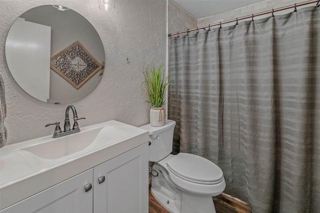 bathroom with hardwood / wood-style flooring, toilet, and vanity