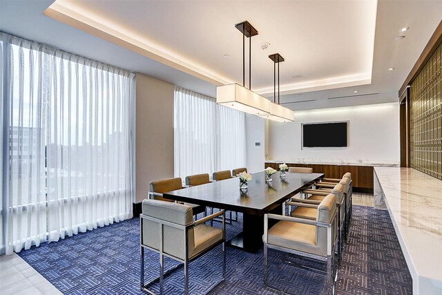 dining area featuring wooden walls and a raised ceiling