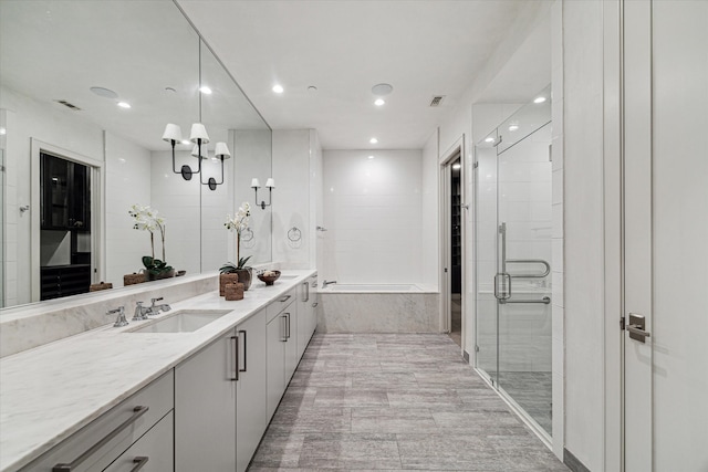 bathroom featuring shower with separate bathtub and vanity