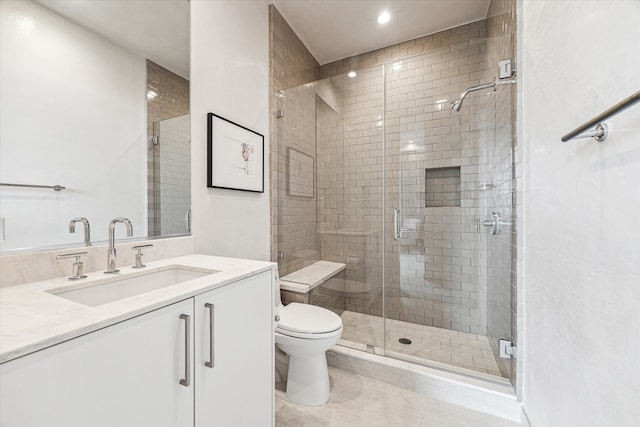 bathroom with a shower with shower door, vanity, and toilet