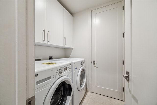 laundry area with separate washer and dryer and cabinets