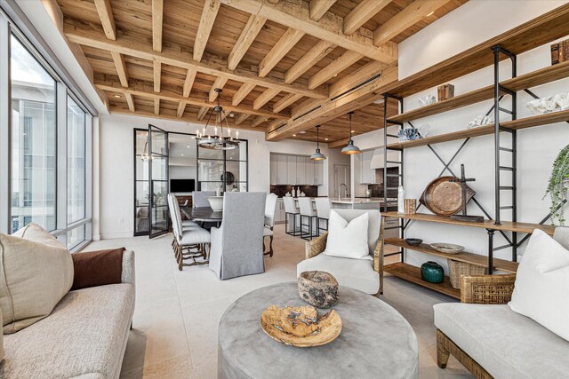 interior space with a notable chandelier, beamed ceiling, wooden ceiling, and sink