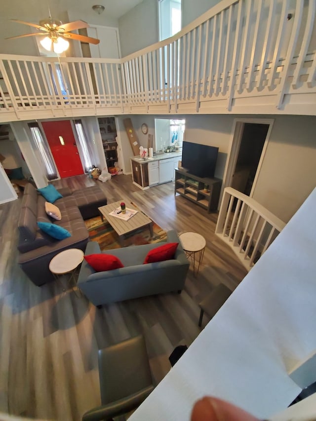 living room featuring hardwood / wood-style floors, a towering ceiling, and ceiling fan