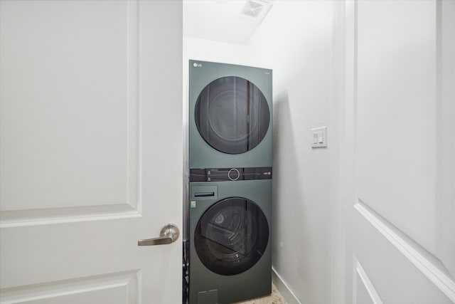 clothes washing area featuring stacked washer / drying machine