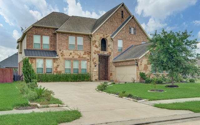 view of front of property with central AC unit, a garage, and a front yard