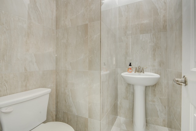 bathroom with tile walls and toilet