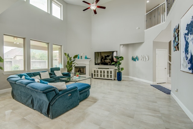 living room featuring tile patterned floors, ceiling fan, and a high ceiling