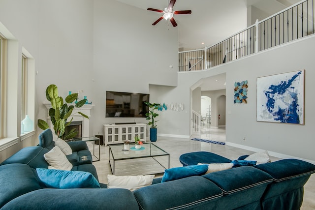 living room featuring tile patterned flooring, a towering ceiling, and ceiling fan